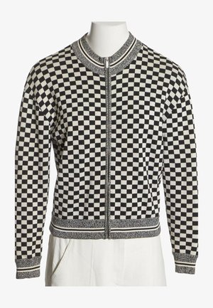 Veste zippée à carreaux noir et blanc avec col, poignets et ourlet côtelés présentant des détails rayés.