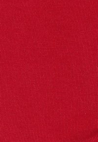 Tessuto a coste rosso con una superficie liscia, caratterizzato da un motivo uniforme di sottili linee verticali. Adatto per diverse applicazioni tessili.