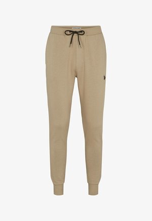 Beige sweatpants van een zachte stof, met een elastische tailleband met een trekkoord, taps toelopende benen en een klein zwart logo op de dij.