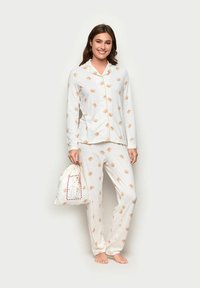 Weißes Schlafanzugset mit einem knöpfbaren Oberteil und passenden Hosen, verziert mit kleinen beigen Bärenillustrationen. Inklusive einer Zugbeutel.