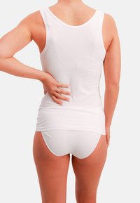 Hvid bomulds-top med rund halsudskæring og glat tekstur, kombineret med hvide trusser. Set bagfra, der fremhæver pasformen og designet.