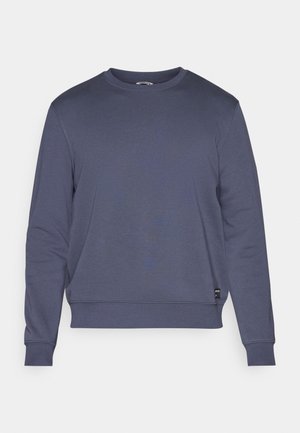 Námořnická modrá mikina vyrobená z měkkého materiálu; má kulatý výstřih, dlouhé rukávy, žebrované manžety a lem, s etiketou na spodní straně.