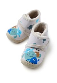 Zapatillas de tela con un exterior suave en color beige, que presentan criaturas marinas de dibujos animados coloridas. Cierre de velcro, punta redondeada y suelas texturizadas.