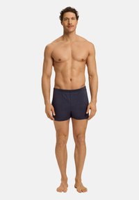 Pánské plavky navy modré barvy vyrobené z lehkého materiálu s elastickým pasem a předním knoflíkem. Hladká textura, délka ke středu stehna.