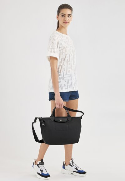 Schwarze Nylon-Tote-Tasche mit zwei Griffen und verstellbarem Schultergurt. Glatte Textur, Fronttasche, Akzente aus silbernem Metall.