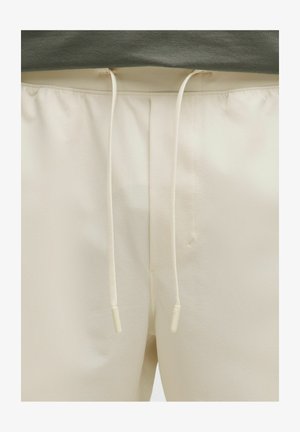 Beez värvilised laiad püksid, mis on valmistatud tekstuursetest kangast, sisseehitatud paelavööga, millel on valged otsad ja minimalistlik disain.