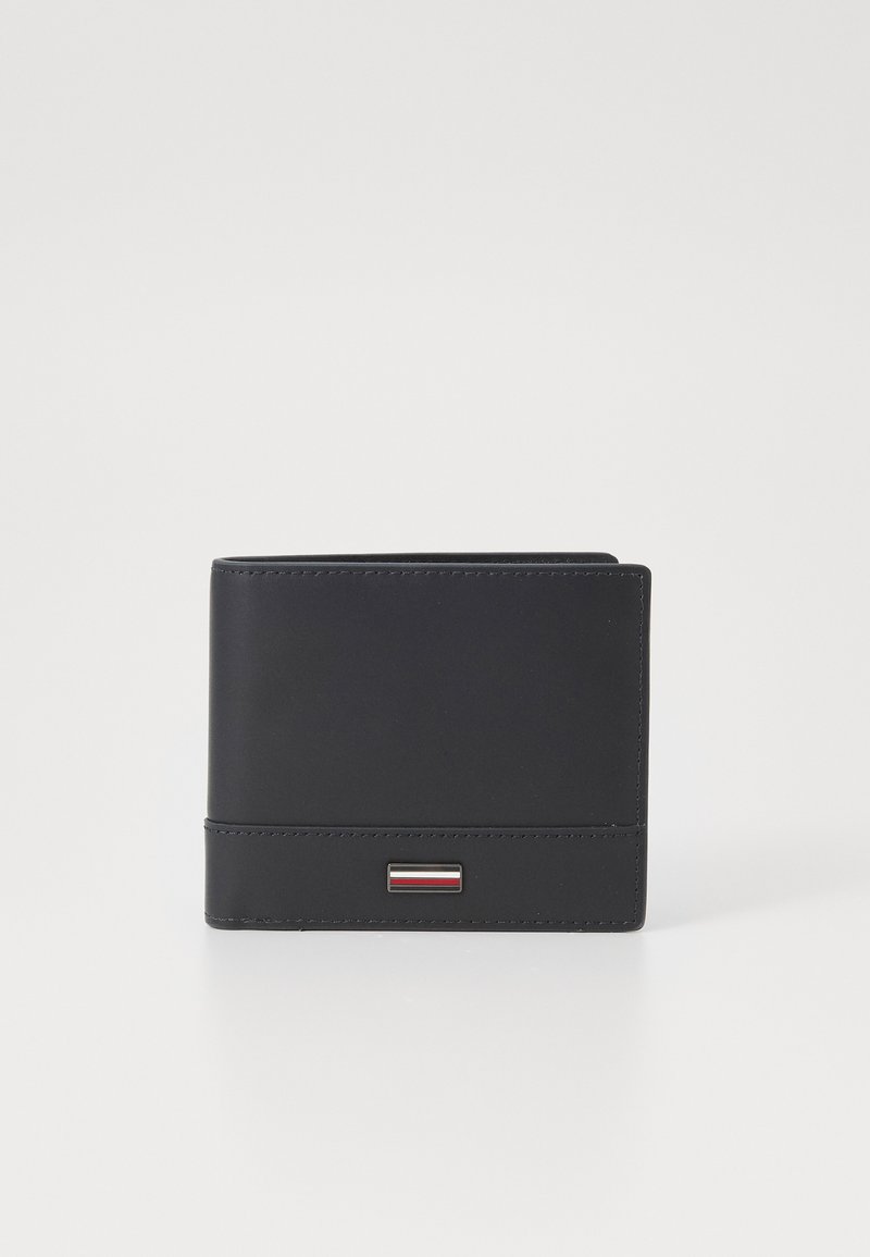 Svart lærpung med minimalistisk design, som har en horisontal aksentstripe og subtile sømdetaljer. Rektangulær form.