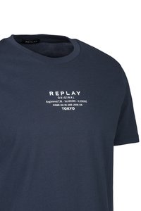 Marineblauwe katoenen t-shirt met een ronde hals; voorzien van witte tekst: "REPLAY ORIGINAL," "REGISTERED T.M.," en "TOKYO."