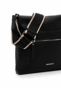 Black textured leather shoulder bag with a zippered pocket, adjustable strap featuring light-colored accents, and gold branding on the front.