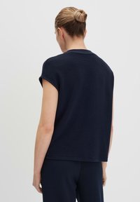 Top blu navy a maniche corte con scollatura rotonda e tessuto testurizzato, caratterizzato da una vestibilità comoda e orlo dritto.