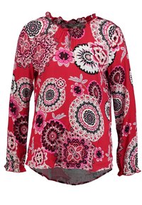 Blusa roja de manga larga con un patrón de mandala floral en rosa, negro y blanco. Cuello y puños con volante, tejido ligero.