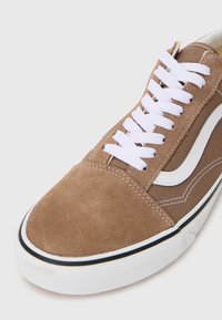 Bruna mocka- och kanvas-sneakers med vita skosnören och sidstripe, med rundad tå och vit gummisåle med svart accent.