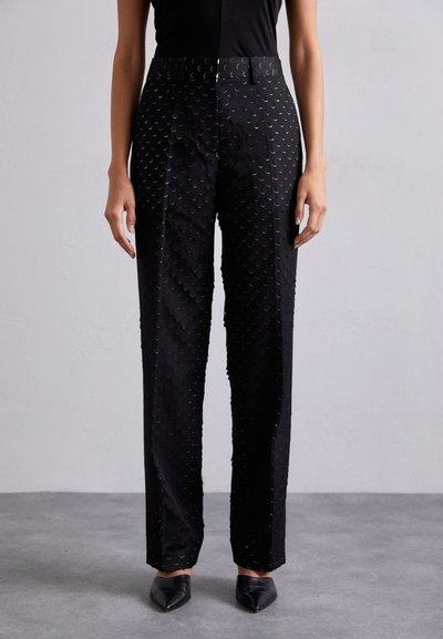 Schwarze Hose mit einem strukturierten Muster aus sich überlappenden kreisförmigen Formen, gerader Schnitt und glänzender Optik.