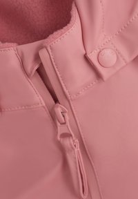 Rosa vattentät jacka med mjukt fleecefoder, med en framsida med dragkedja och tryckknappsstängning. Sömdetaljer är synliga.