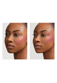 Profile views of a face, left with a soft pink blush, right with a deeper pink blush. Smooth skin, natural makeup, and symmetrical features.