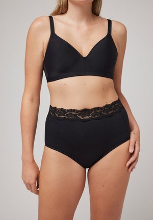 Sutiã sem fio negro con un acabado suave y un escote en V profundo. Ropa interior negra de cintura alta con un borde de encaje en la cintura.