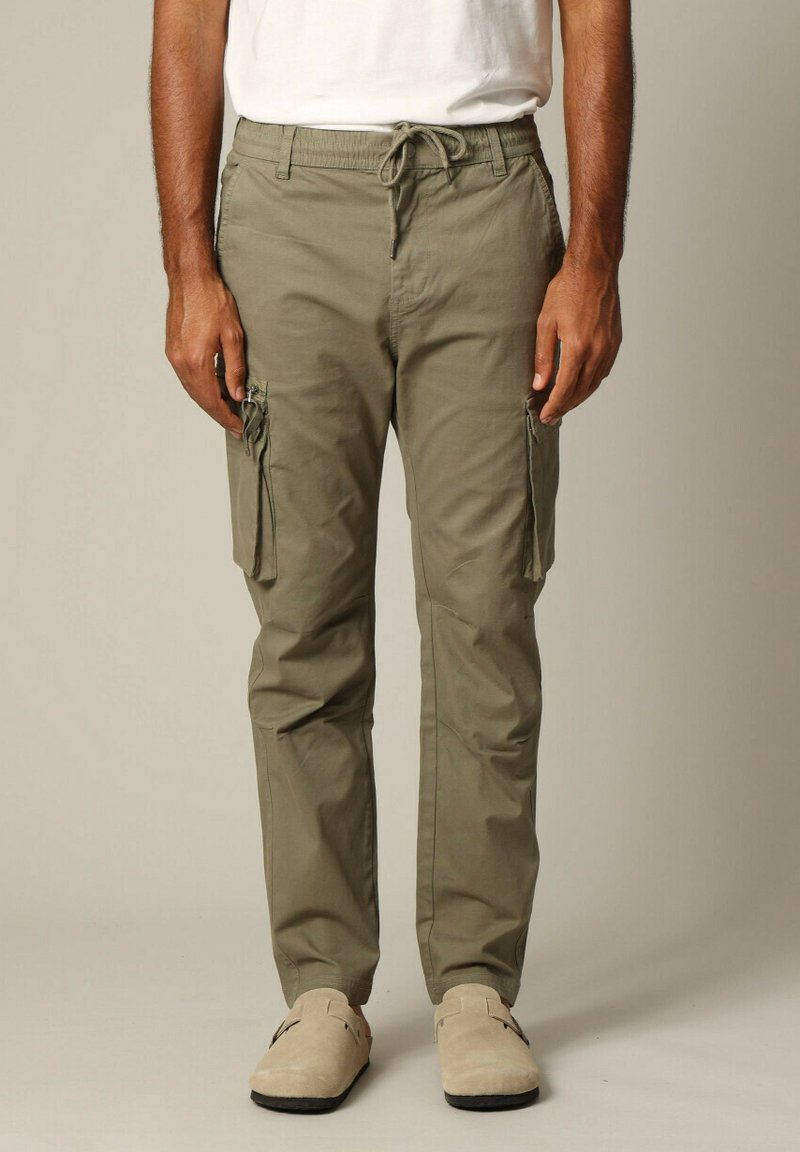 Kaki cargobroek met een elastische tailleband, trekkoord, zijzakken en een zachte, gladde textuur. Strak en tapse pasvorm.