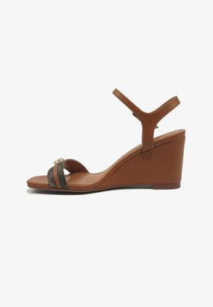 Rudos spalvos pleišto formos basutės su kulkšnies dirželiu, juodu ir auksiniu dekoratyviniu priekiu bei vidutinio aukščio kulnu.