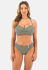 Zwart en crèmekleurig gebreid bikini met een gestructureerde top en hoog uitgesneden onderkant, voorzien van een gouden accent aan één kant. Glad stofoppervlak.