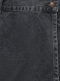Gros plan sur un tissu en denim noir avec une poche avant présentant des coutures visibles et un bouton en laiton sur le bord supérieur.