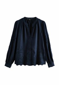 Chemisier bleu marine à boutons et manches longues, présentant des broderies florales à l'avant et une hem décorative. Tissu lisse avec une coupe décontractée.