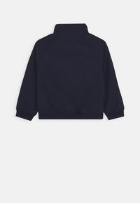 Marineblauwe lange mouwen jas met een staande kraag, elastische manchetten en een elastische zoom, vanaf de achterkant gezien.