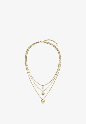 Gelaagde gouden ketting met drie rijen, met kettingen die een witte kraal, een zonhanger en een hartvormige hanger bevatten, op een witte achtergrond.