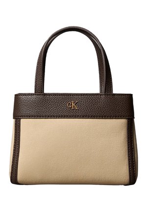 Bolso de mano de lona beige con detalles y asas de piel marrón oscuro, con un pequeño logo dorado "cK" en el frente.