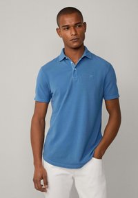 Kurzärmeliges, blaues Poloshirt aus weichem Stoff mit Kragen, Drei-Knopf-Leiste und dezentem Logodetail auf der Brust.