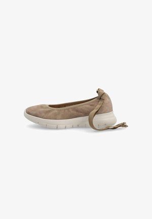 Zapato tipo slip-on de ante marrón claro con suela de goma blanca y tira en el tobillo atada con un lazo, mostrado de lado sobre un fondo blanco.