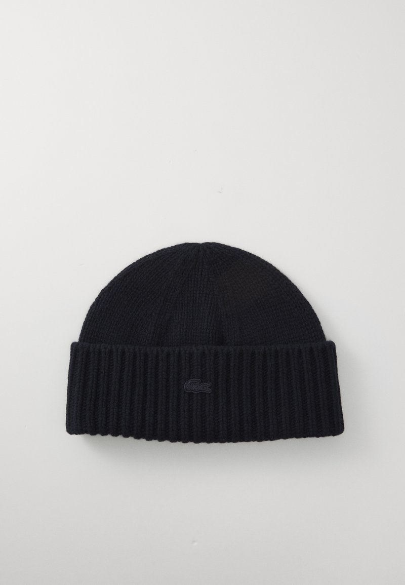 Navy knitted beanie with a ribbed texture, featuring a folded cuff and a small embroidered logo on the front.