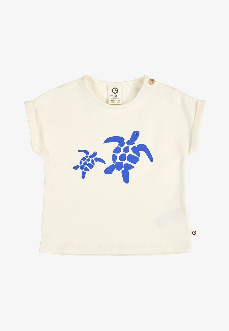 Chemise pour bébé couleur crème avec deux graphismes de tortues marines bleues sur le devant et un bouton en bois sur l'épaule.