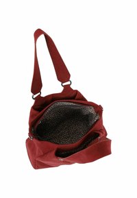 Rode suede schoudertas met verstelbare schouderriem, met een ruime binnenkant gevoerd met een patroonstof. Inclusief ritsvak.