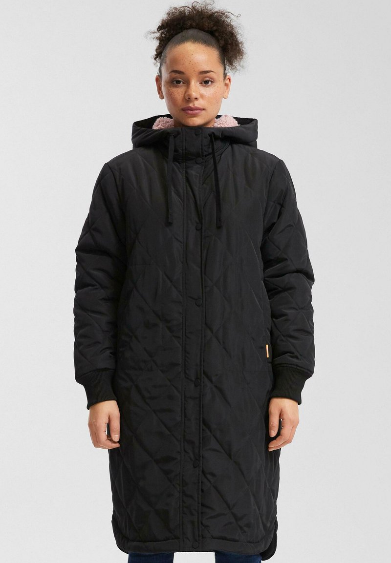 Zwarte gewatteerde lange jas met capuchon, voorzien van een roze fleece voering en ribgebreide manchetten. Minimalistisch design met een knoopsluiting.