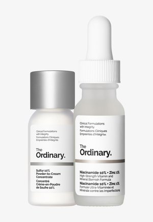 Deux flacons de soin pour la peau de la marque The Ordinary : un Soufre 10 % poudre-à-crème, un sérum Niacinamide 10 % avec Zinc 1 % avec bouchon compte-gouttes.