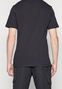 Černé bavlněné tričko, kulatý výstřih, krátké rukávy, hladká textura, přiléhavý střih, viditelné švy, minimalistický design bez grafiky.