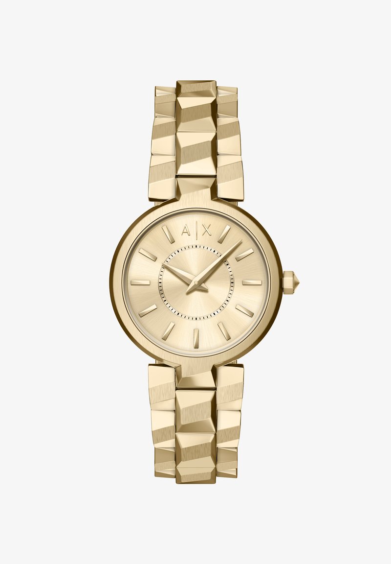 Montre dorée avec un boîtier rond texturé et un bracelet assorti épais. Les index horaires sont minimalistes avec un cadran brossé élégant et un logo.