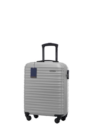Silver hard-shell suitcase with vertical ribbed texture, two wheels, telescopic handle, and a blue tag attached. Brand: WITTCHEN.