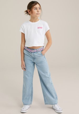 Camiseta blanca corta con estampado rosa de "BLOOM", combinada con unos vaqueros de pierna ancha de rayas azules claras y un cinturón rosa. Unas deportivas completan el look.
