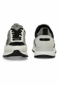 Scarpe sportive con una tomaia in mesh nero, dettagli in pelle grigia, suole bianche e lacci neri. Nella parte posteriore presentano un'etichetta nera e un dettaglio intagliato.
