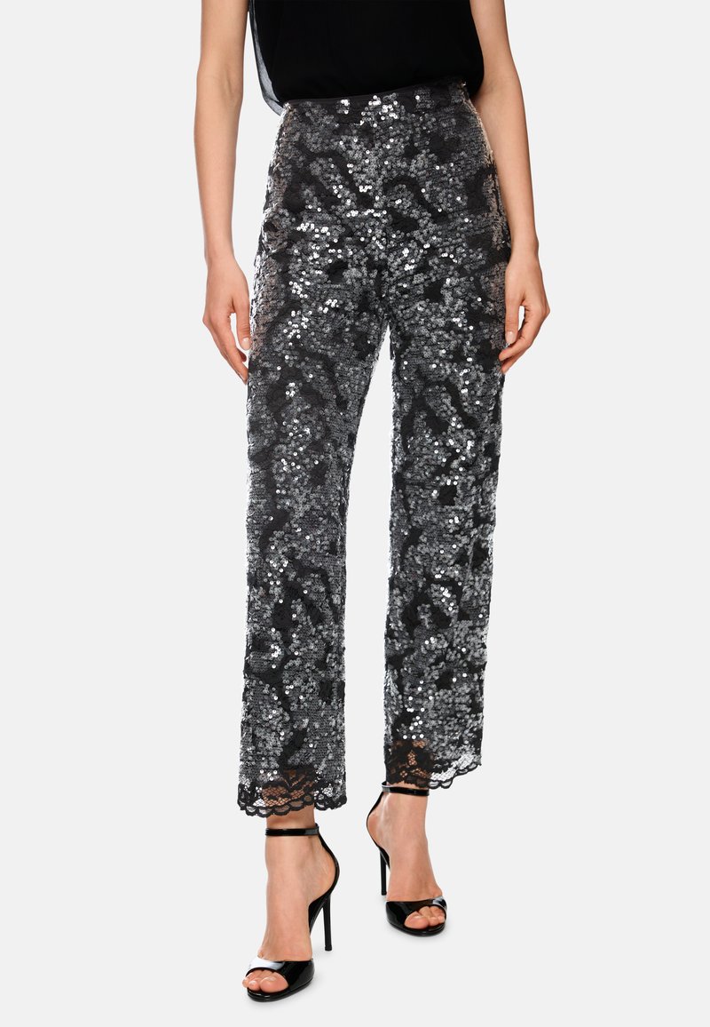 High-waist black pants with silver sequins and lace hem, worn with black sleeveless top and black high-heeled sandals.