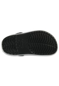 Suola di scarpa in gomma nera con un motivo di battistrada testurizzato, caratterizzato da forme a zigzag in rilievo e incisioni circolari per la trazione.