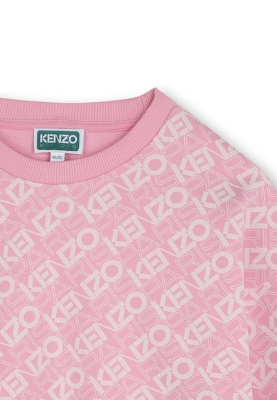 Sweatshirt rose avec un motif de logo blanc répétitif, col à côtes et texture douce. Convient pour les vêtements pour enfants.