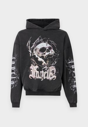 Svart hettegenser med en stor grafikk av en hodeskalle innviklet i piggtråd og klør, med stilisert tekst under og på ermene.