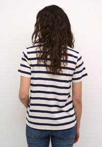T-shirt rayé en crème et bleu marine, à manches courtes et à coupe décontractée. Matière en coton doux avec une texture lisse.