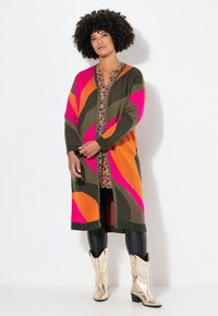 Long cardigan en maille avec des motifs en rose, orange et vert. Le tissu texturé a une fermeture à boutons sur le devant et des manches larges.