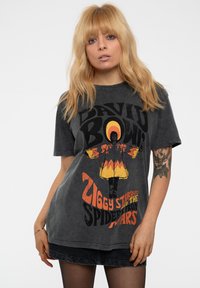 Grey oversized t-shirt featuring a faded graphic of David Bowie in a colorful costume with "Ziggy Stardust" text in orange and black.