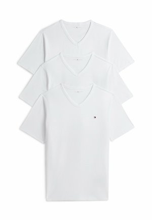 Trzy białe koszulki z dekoltem w serek ułożone w stos, każda z krótkim rękawem; na przodzie pierwszej koszulki znajduje się małe logo w kolorach czerwonym, białym i niebieskim na wysokości klatki piersiowej.