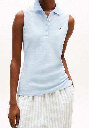 Polo sin mangas de color azul claro con cuello y botones, usado con pantalones a rayas blancas y gris claro.