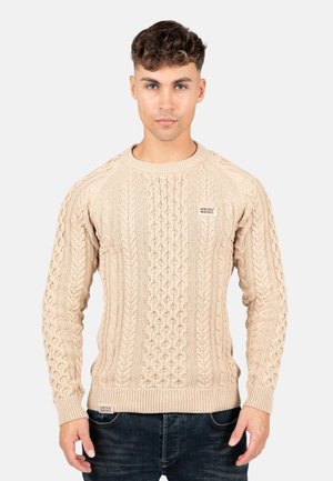 Beige kabelstrik sweater med ribbet rullekrave og manchetter. Har teksturerede mønstre og et lille logo-tag på den nederste del foran.
